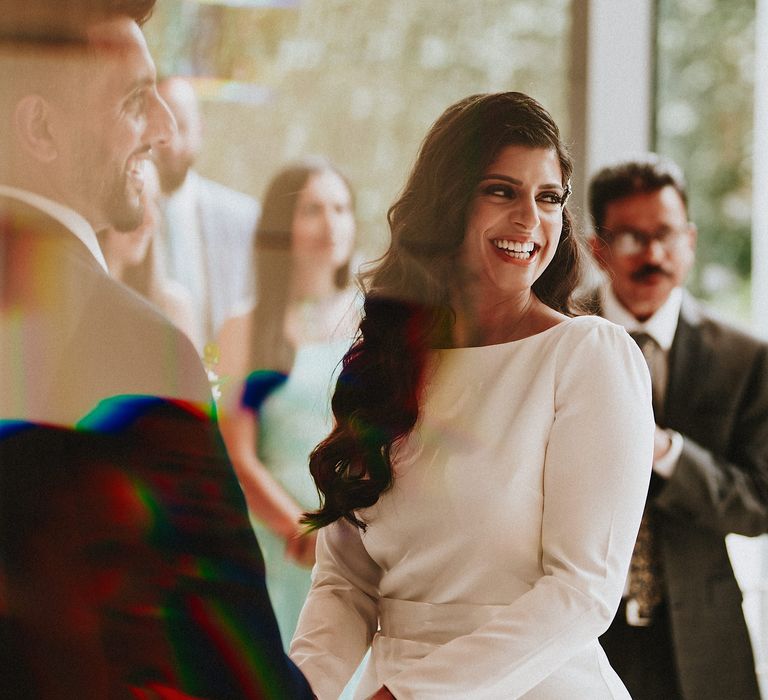 Bride with long wavy hair smiling during her wedding ceremony 