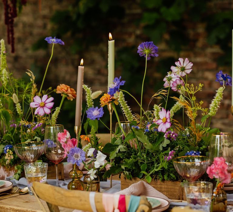 Wildflower plant box centrepiece flowers with flower stems in vases, and colourful taper candles for fiesta theme wedding 