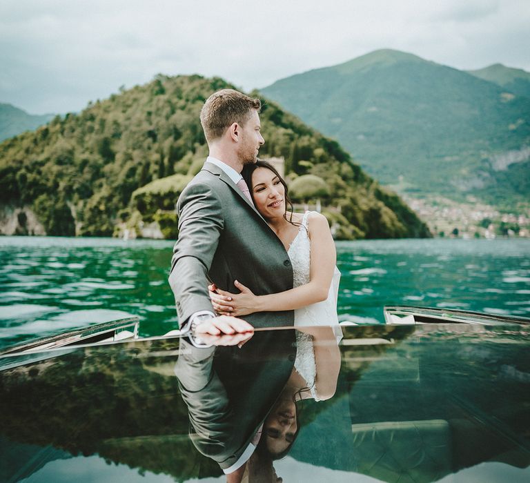 Bride & groom wrap their arms around one another on their wedding day on Lake Como