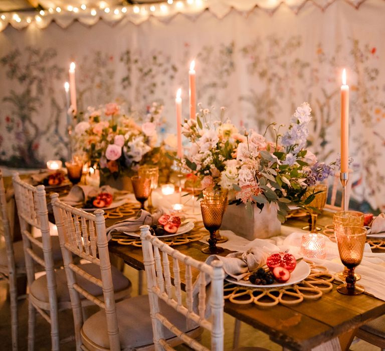 Rustic wedding table with pastel florals and candles, amber glassware and table runner for modern marquee tent wedding reception