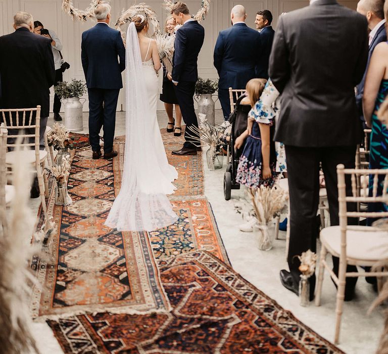 Bride & groom stand at the end of the aisle on their wedding day