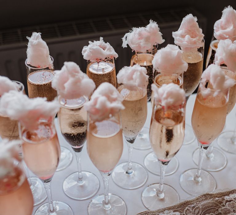 Pink sparkling fizz in champagne flutes with pink candyfloss