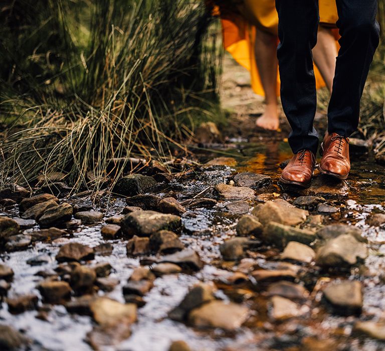 Bride & grooms feet against rocks outdoors 