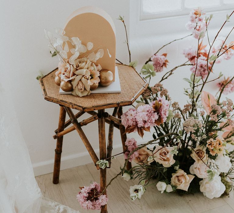 Wooden side table with floral arrangement and wedding cake 