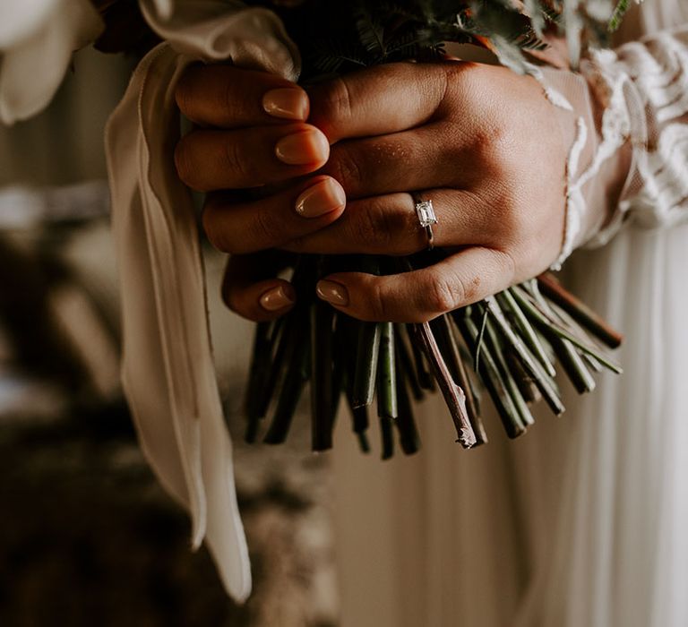 Bride's nude nails with rectangle diamond engagement ring