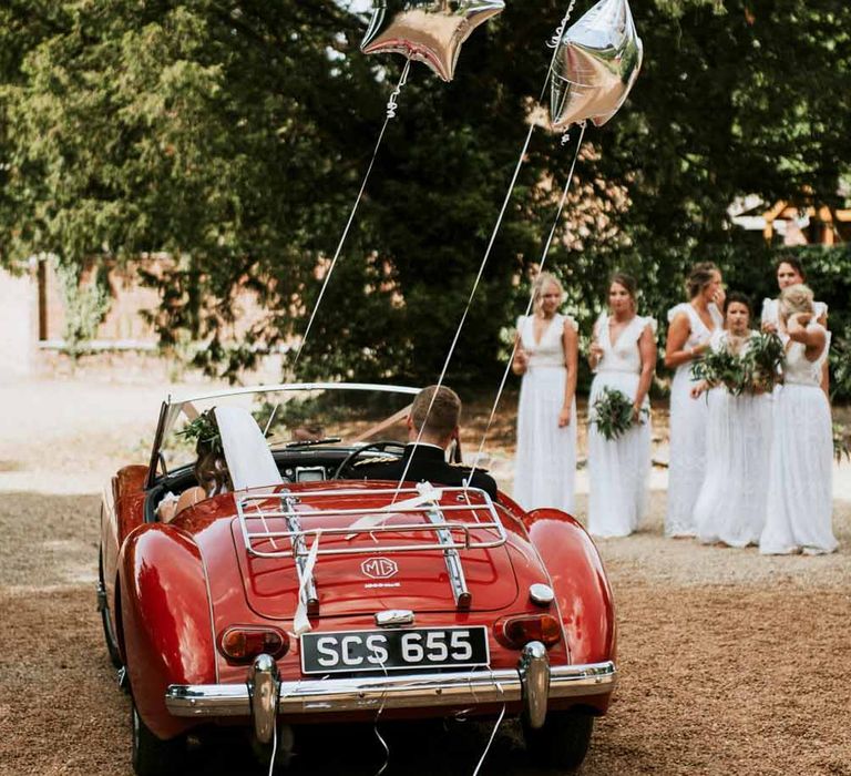 Red convertible wedding car with silver star balloons 