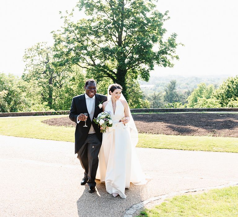 Bride and groom walk around the grounds of their Pembroke Lodge wedding venue