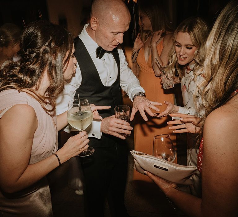 Guests gather to look at the groom's new wedding band 