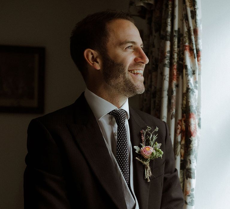 Wedding guest in morning suit with grey waistcoat and spotted tie 