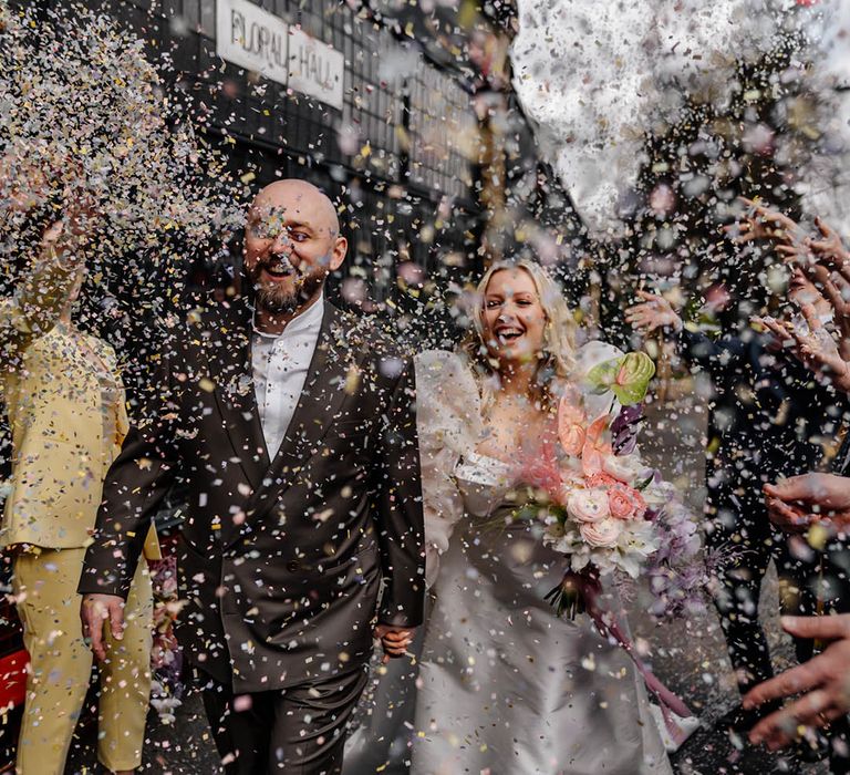 Confetti moment at stylish London wedding with groom in a double breasted suit and bride in a JESUS PEIRO wedding dress