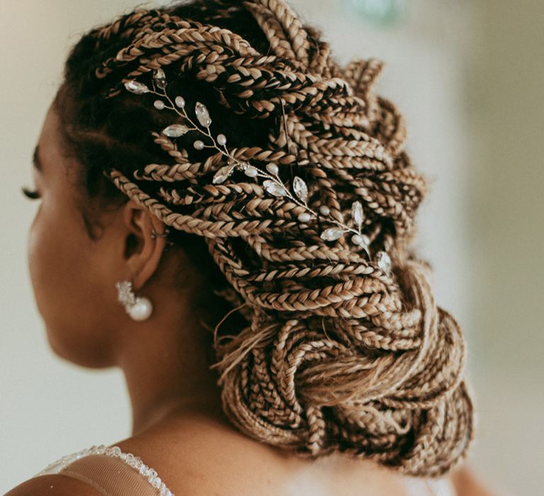 Bride with blonde braids put into an updo with a jewelled hair accessory 