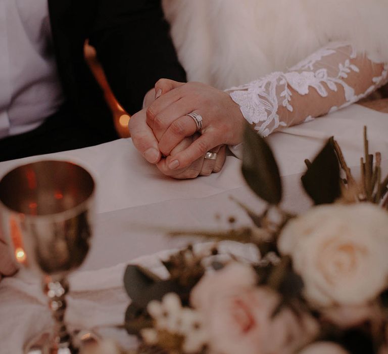 Silver wedding rings worn by the bride and groom at their winter wedding 