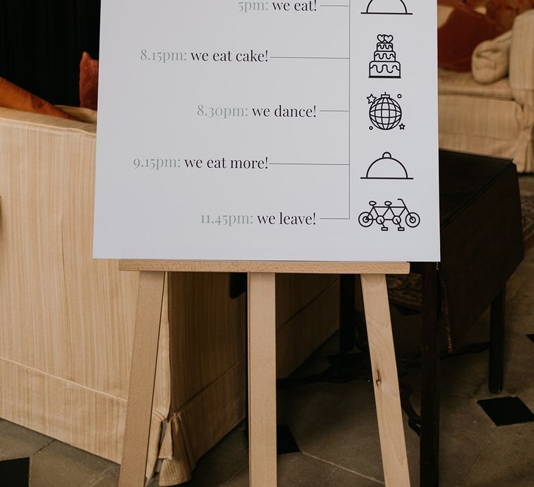 Minimalistic funny order of the day wedding sign on wooden easel at Kelmarsh Hall