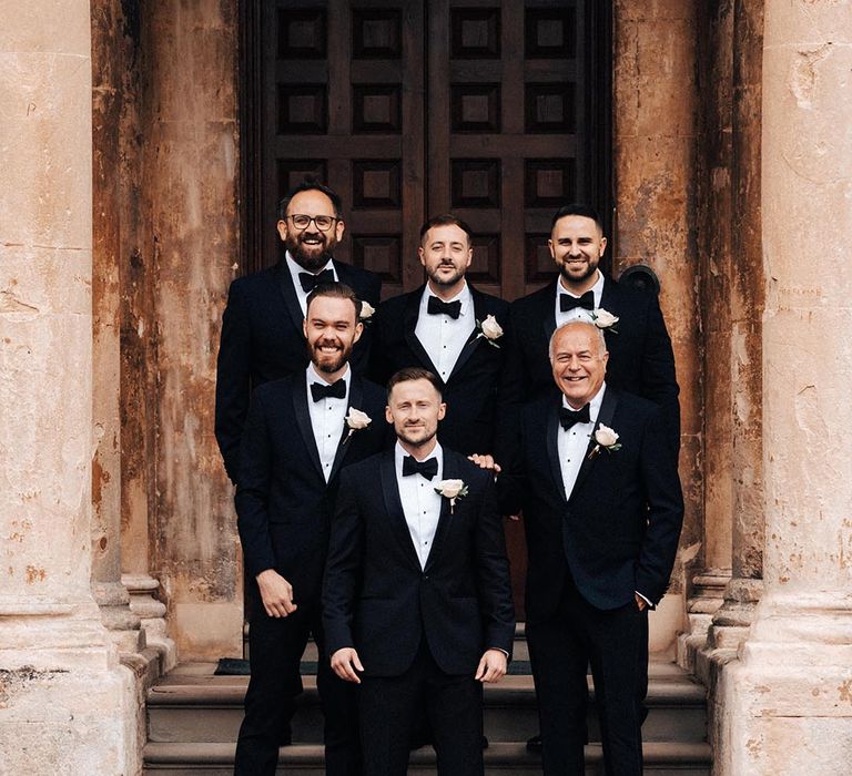 Groomsmen all stand together in black tie for the classic and traditional country house wedding 