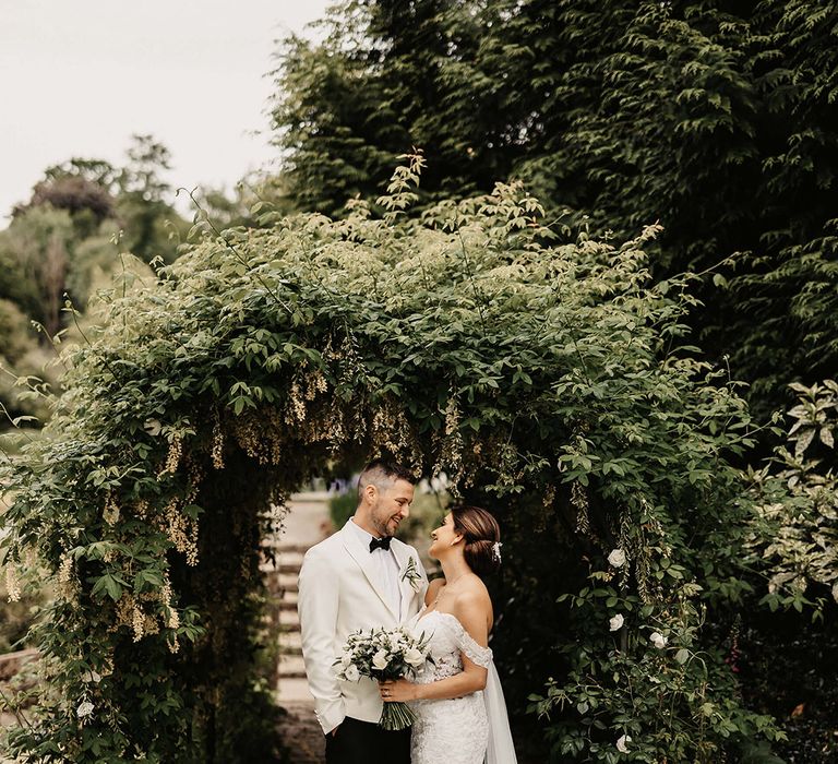 The bride and groom gaze into each other's eyes as they pose for their couple portraits in the grounds at The Orangery in Kent 