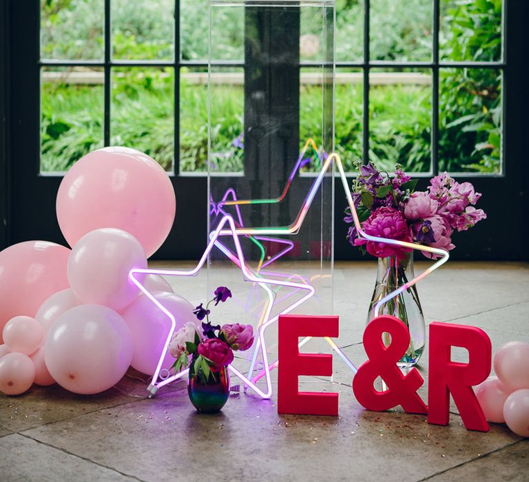 pink and red balloons and three tiered butercream cake