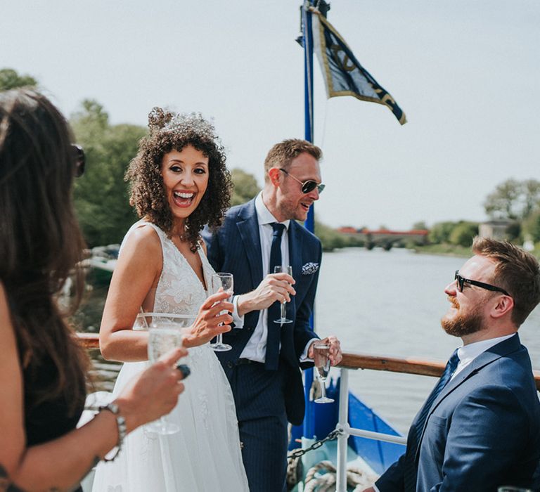 Curly haired bride wears pearl bridal crown during Thames boat ride 