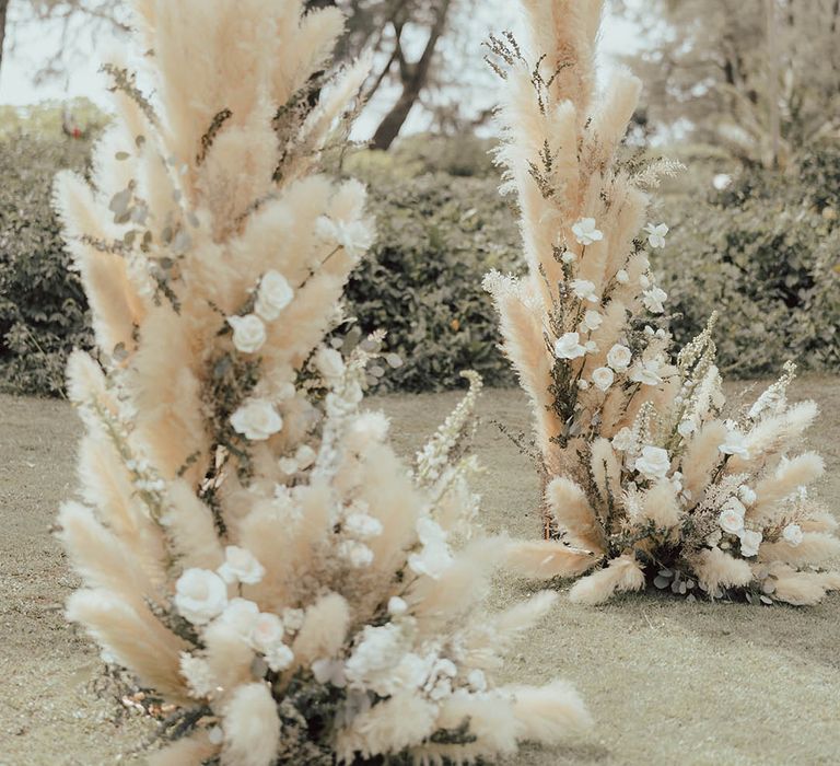 Fluffy pampas grass with white roses and wildflowers for outdoor wedding ceremony 