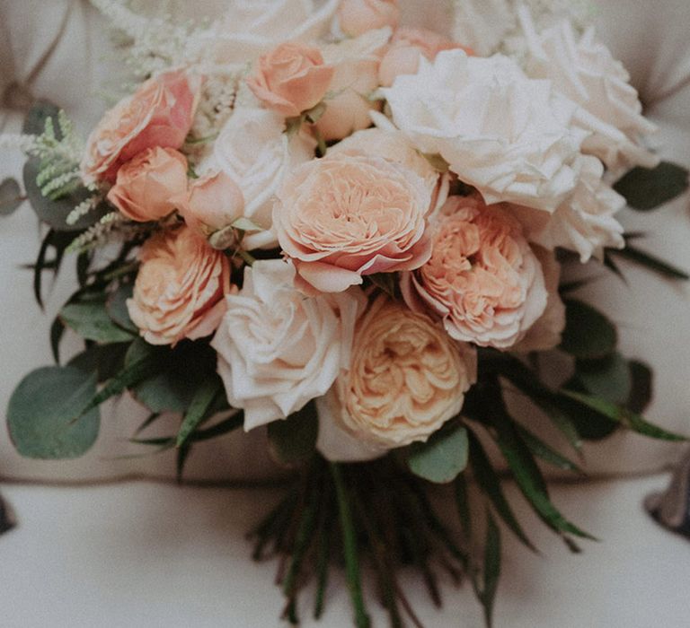 Baby pink and white rose and peony wedding bouquet and green foliage 