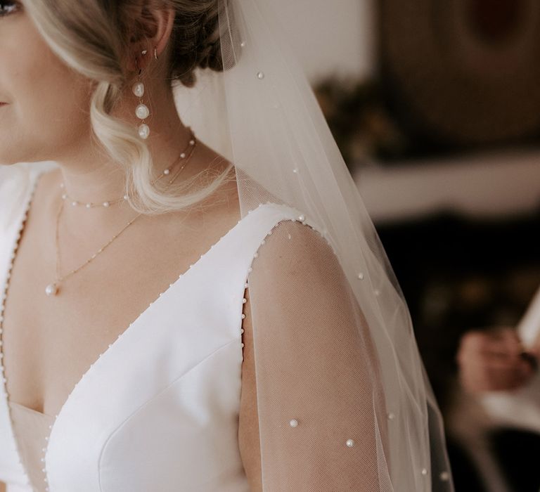 Bride in a Maggie Sottero wedding dress with a pearl veil and jewellery 