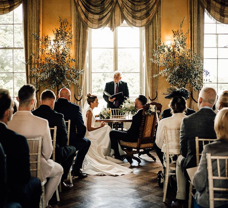 The bride and groom stand at the altar for their Hampton Court House wedding ceremony 