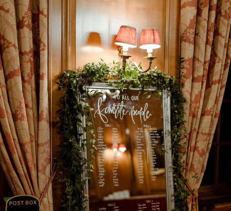 Mirrored wedding table plan with foliage decorations at Inner Temple Hall