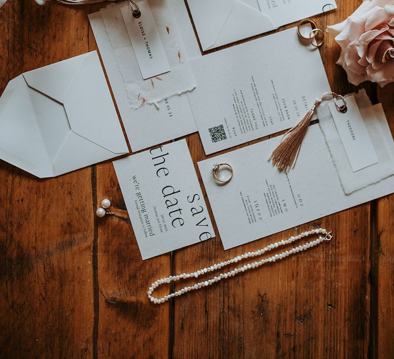 Classic wedding stationery with the bride's pearl wedding jewellery and metallic bridal shoes 