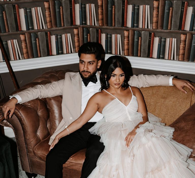 Groom in beige suit jacket with bride in layered tulle reception dress by Alena Leena 