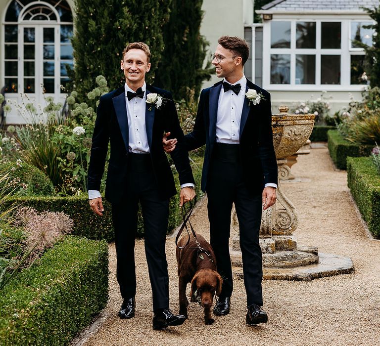 The two grooms pose with their beloved pet dog who is the Dog of Honour at their wedding 