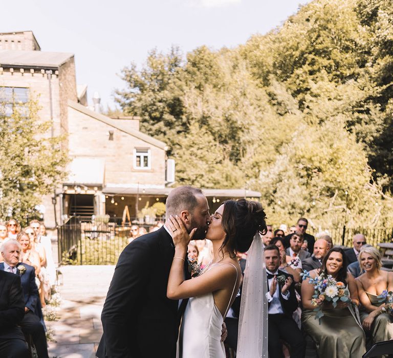 The bride and groom share their first kiss as a married couple 