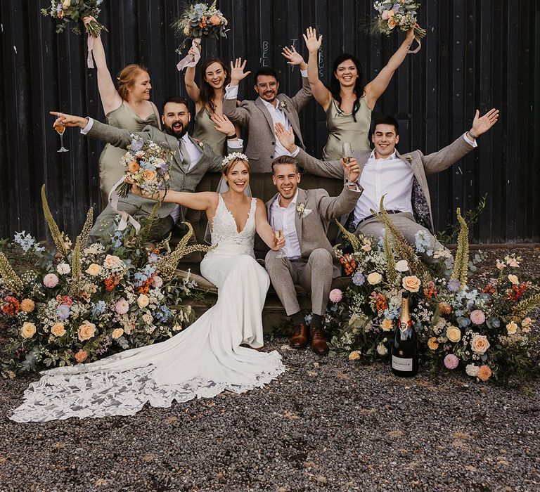 Green wedding party wearing satin bridesmaid dresses from Pretty Lavish holding pastel wedding bouquets 