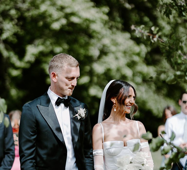 Monochrome chic wedding with the groom in a black tux and bride in satin wedding dress 