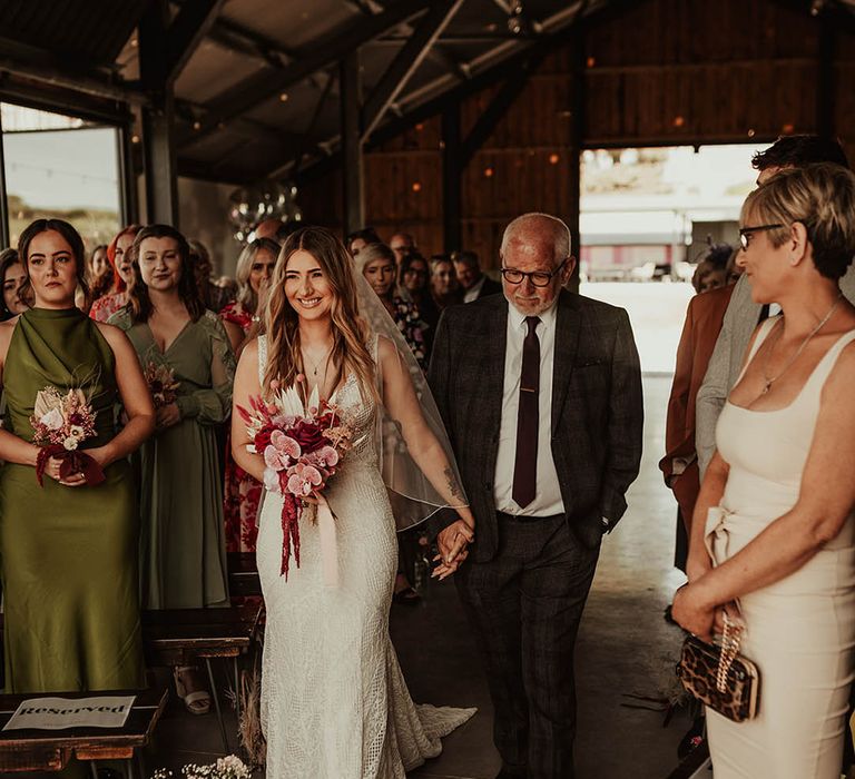 Bride in boho lace wedding dress walking down the aisle with the father of the bride in checkered suit at The Giraffe Shed 