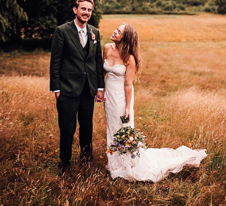 Groom in dark green wedding suit with the bride in a strapless wedding dress 