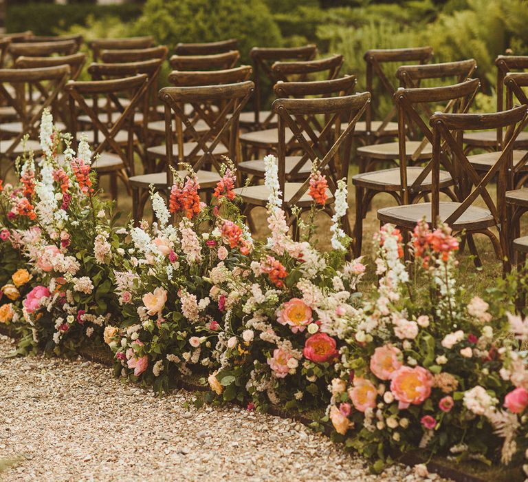 Long row of wedding flowers with pink, orange, and white wedding flowers including peonies, foxgloves, and other bell flowers