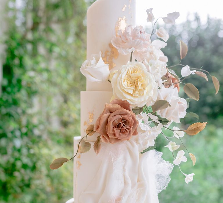 Luxury wedding cake with handcrafted flowers with gold flakes 