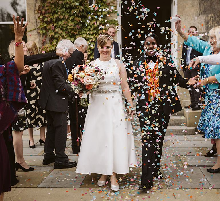 Colourful pastel confetti moment for the two brides at their lesbian wedding 