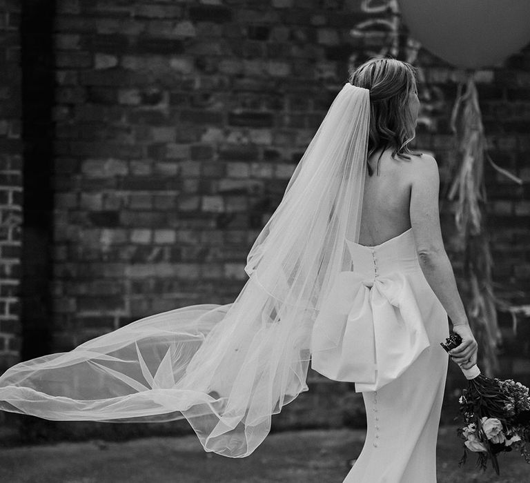 Bride wearing strapless bow wedding dress with veil 