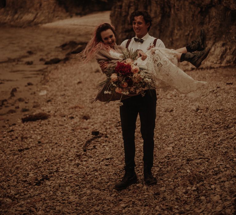 Groom picking his bride up at Lake District elopement wedding