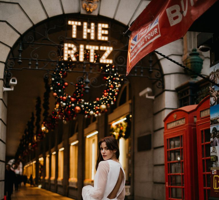 Bride in mini wedding dress with midi sheer layer and backless details