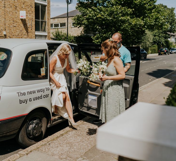 Bride arriving in a cab in a White by Vera Wang wedding dress 