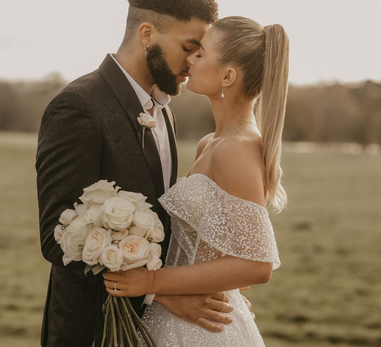 Bride and groom kissing at elegant Gosfield Hall Christmas wedding 