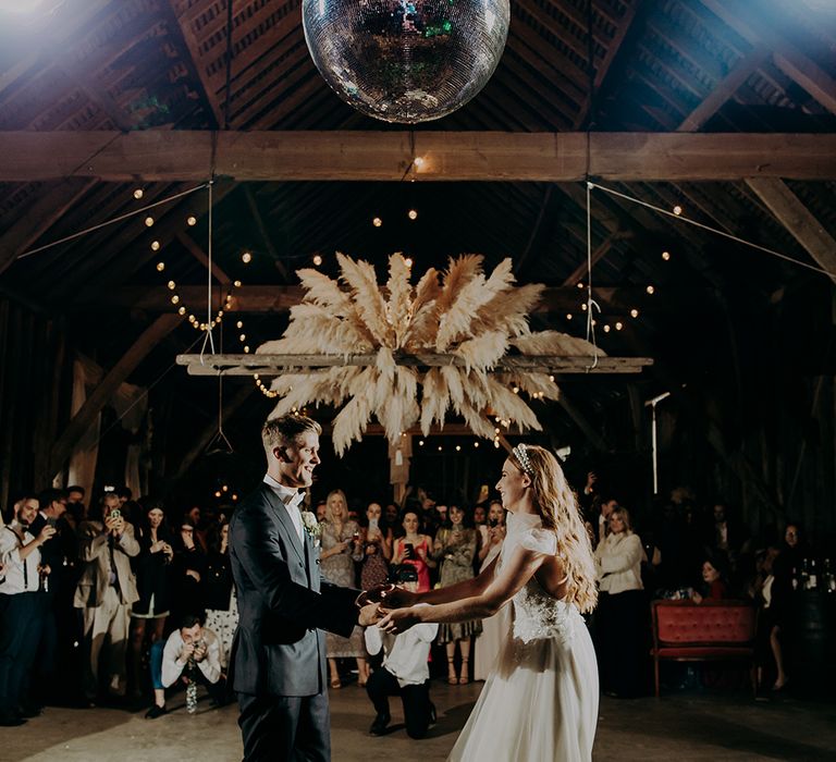 Bride and groom first dance under a disco ball 