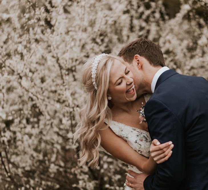 Groom kissing his brides neck and making her laugh 