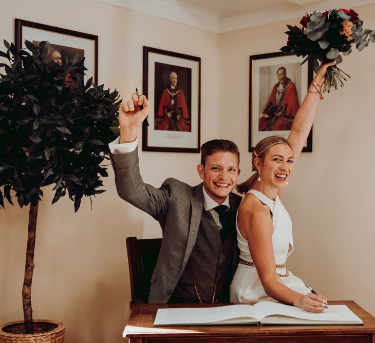 Bride and groom signing the register at intimate micro wedding 