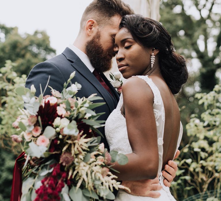 Bride and groom portrait with the bride in a V back wedding dress 