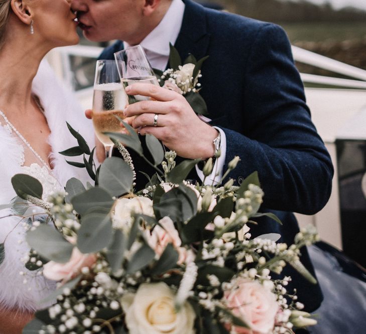 Newly married couple with pink roses and champagne on their wedding day