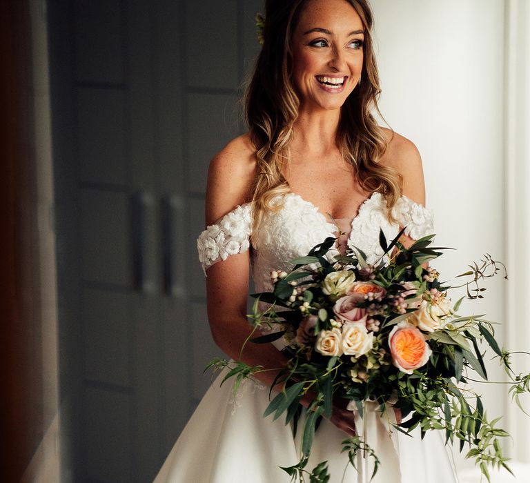 Cold shoulder wedding dress and peach bridal bouquet 