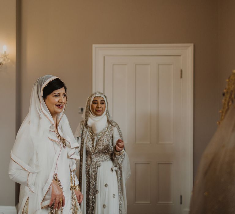 Mother of the bride in a ivory and gold sari on the wedding morning 