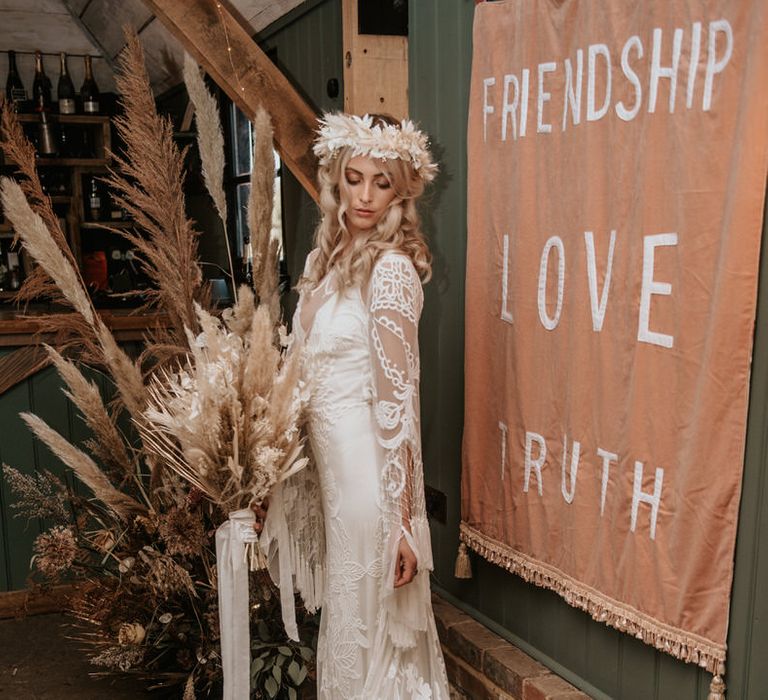 Bride stands in front of velvet wedding wall banner signage